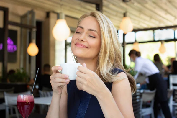 目を閉じてコーヒーを飲むゴージャス女性カフェバー — ストック写真