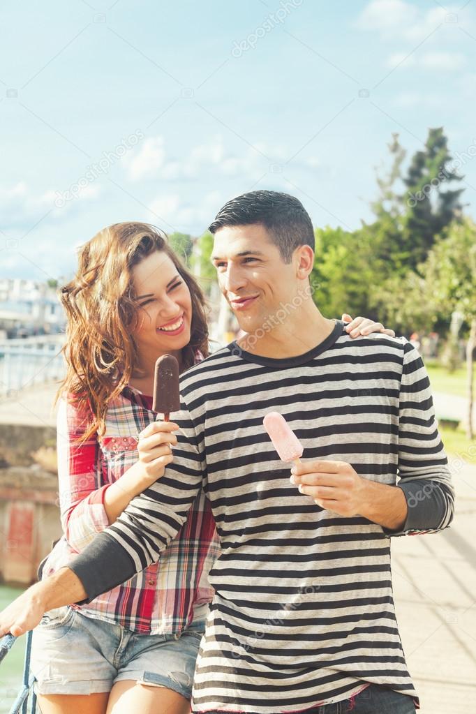 Happy couple outdoors eating ice cream