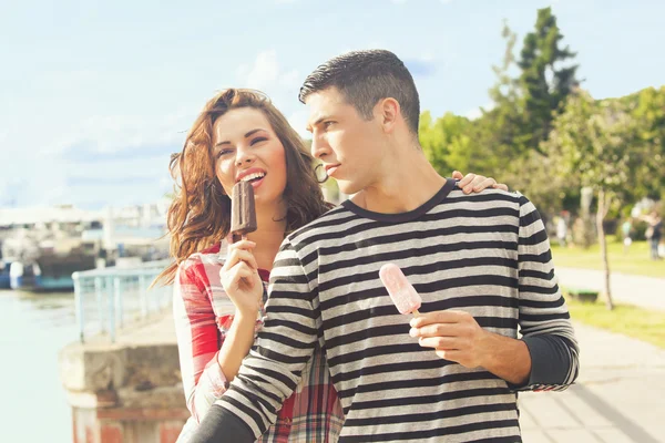 Casal feliz comer sorvete ao ar livre em um dia ensolarado — Fotografia de Stock