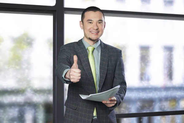 Zakenman holding documenten en geven duimen omhoog — Stockfoto