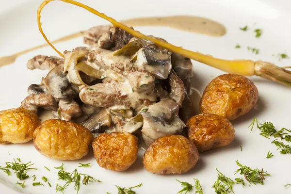 Boeuf à la sauce aux champignons servi avec des pommes de terre rôties — Photo