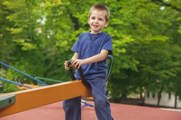 Cute boy on a see-saw — Stock Photo, Image