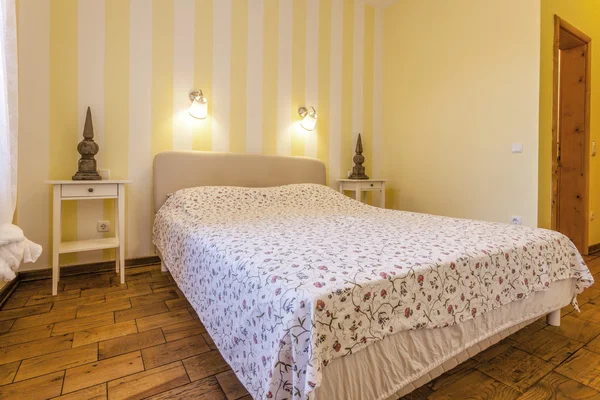 Interior of a simple bedroom with yellow walls — Stock Photo, Image