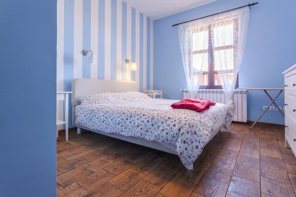 Interieur van een eenvoudige slaapkamer met blauwe muren — Stockfoto