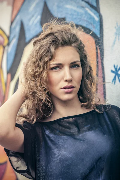 Junge Stadtfrau vor Grafitti-Wand — Stockfoto