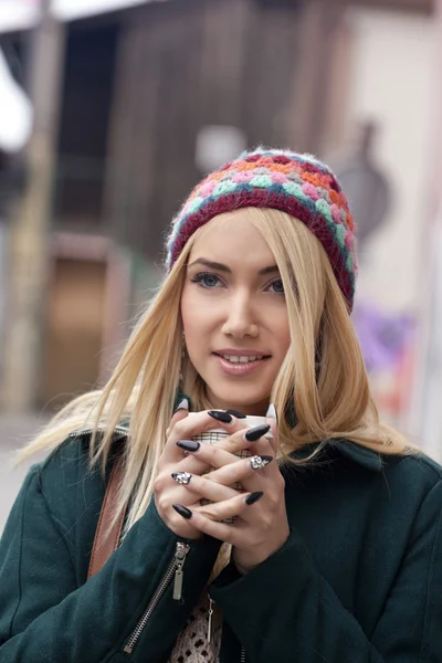 Young woman keeping warm with a hot drink ooutdoors — Stock Photo, Image