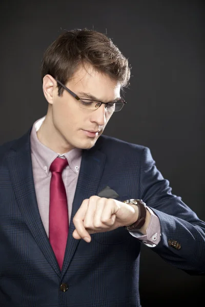 Beau homme d'affaires avec des lunettes regardant la montre — Photo