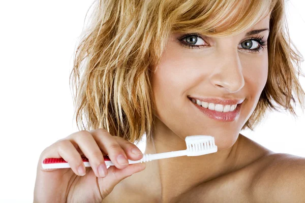 Kaunis nainen harjaamalla hampaat eristetty valkoinen — kuvapankkivalokuva
