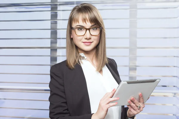 Mujer de negocios con gafas sosteniendo la tableta —  Fotos de Stock