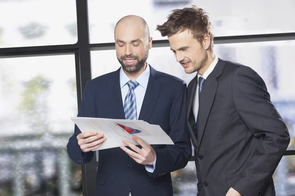 Deux hommes d'affaires regardent les documents — Photo