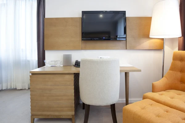 Chaise, bureau et télévision dans l'intérieur de la chambre d'hôtel — Photo