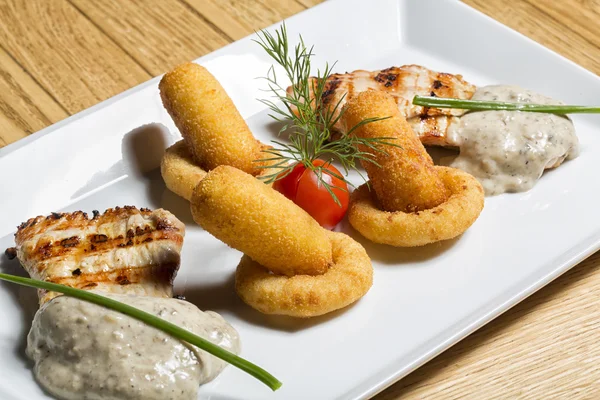 Squid, croquettes and chicken in mushroom sauce — Stock Photo, Image