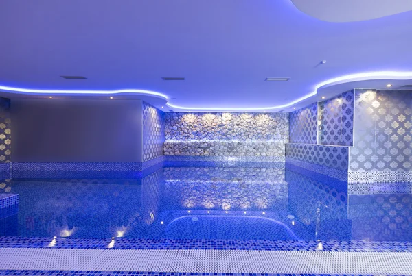 Piscina interior con luces de colores en el centro de spa — Foto de Stock