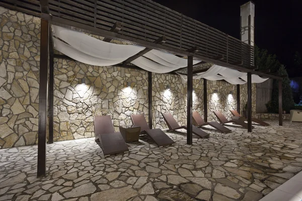 Sillas de salón junto a la piscina por la noche — Foto de Stock