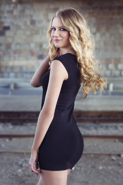 Schöne blonde Frau im schwarzen Kleid — Stockfoto