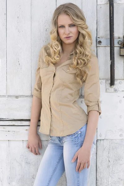 Beautiful young woman posing in shirt and jeans — Stock Photo, Image