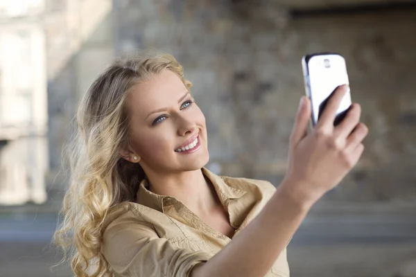 Beautiful girl taking a selfie outdoors — Stock Photo, Image
