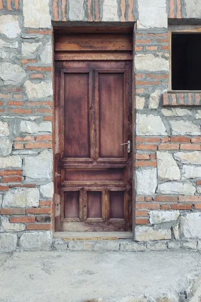 Porta de madeira em uma casa de pedra — Fotografia de Stock