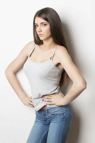 Portrait of a young woman in jeans and spaghetti strap top — Stock Photo, Image