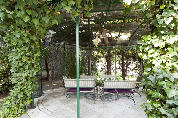 Gazebo in garden with table and chairs — Stock Photo, Image