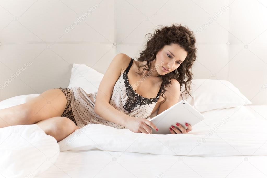 Beautiful woman in bed with tablet
