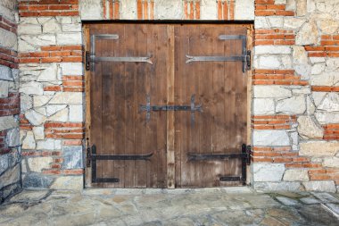 Old wooden gate on a stone building