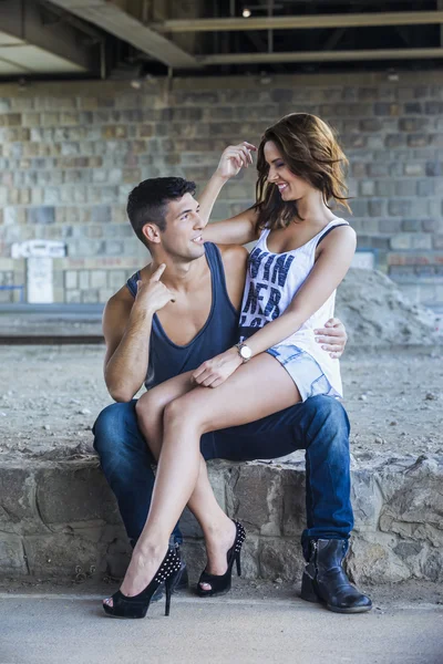 Ung kvinna sitter i pojkvännens knä — Stockfoto