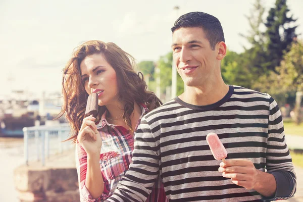 Young couple eating ice cream on a sunny day — Stock Photo, Image