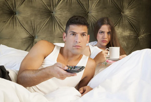 Couple watching TV with worried expression — Stock Photo, Image