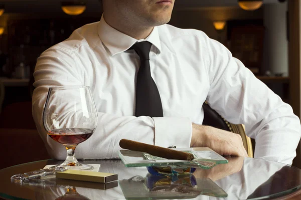 Człowiek siedzi w barze z koniaki i cygara — Zdjęcie stockowe