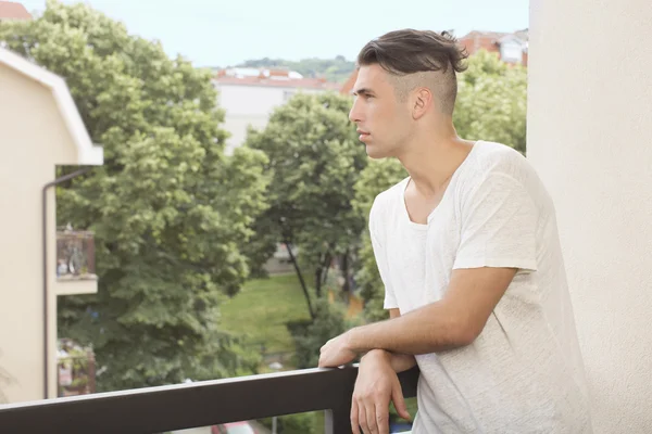 Jonge man op het balkon — Stockfoto