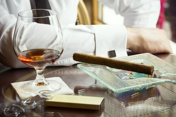 Man sitter i en bar med cognac och cigarr — Stockfoto