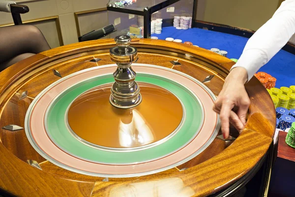 Croupier girando la ruleta en el casino — Foto de Stock