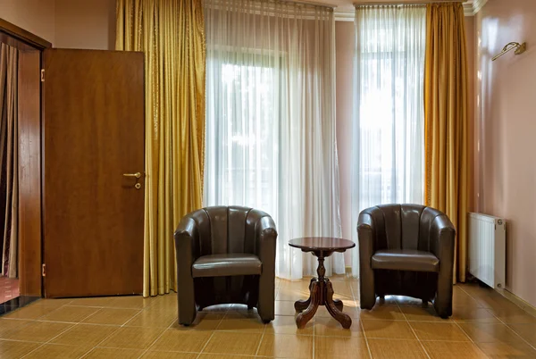 Křesla a stůl v interiéru pokoje hotelu — Stock fotografie