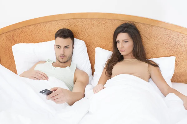 Casal assistindo TV na cama — Fotografia de Stock