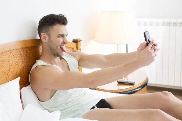 Young man making a face and taking a selfie — Stock Photo, Image