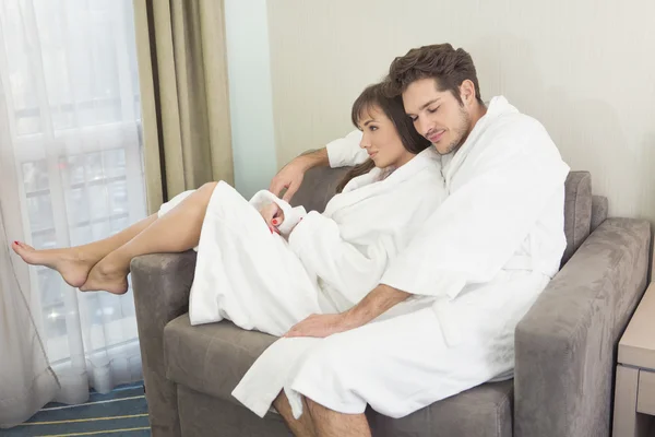 Jong paar in badjassen ontspannen samen — Stockfoto
