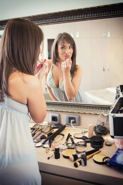 Vrolijke jonge vrouw voor toepassing van make-up spiegel — Stockfoto