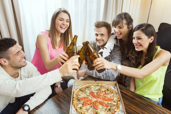 Grupo de amigos tomando cerveza y pizza en casa — Foto de Stock