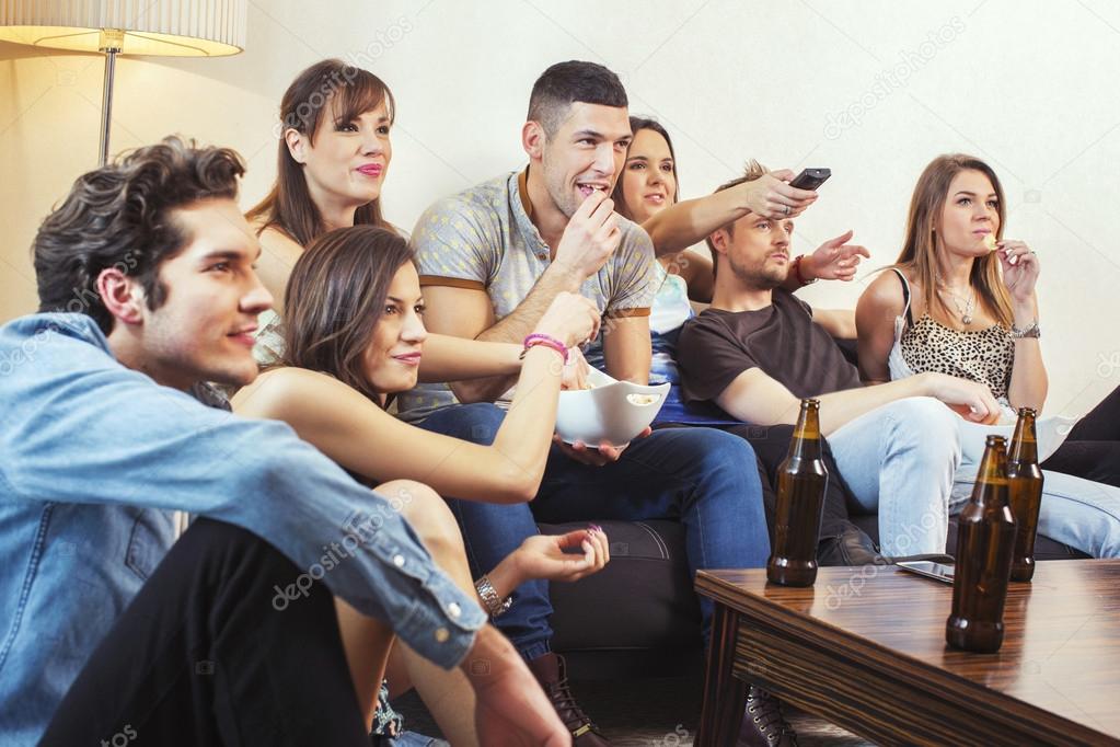 Group of friends watching TV at home