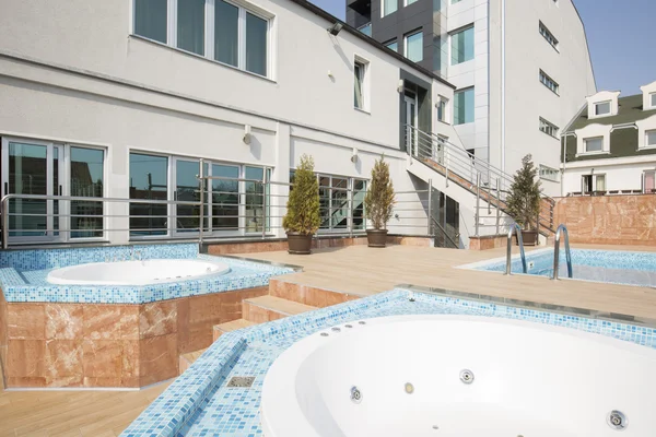 Piscina y bañeras de hidromasaje frente a un edificio moderno — Foto de Stock