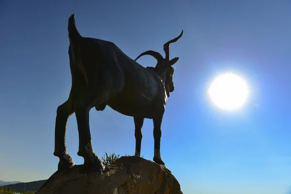 goat statue sunrise and sun