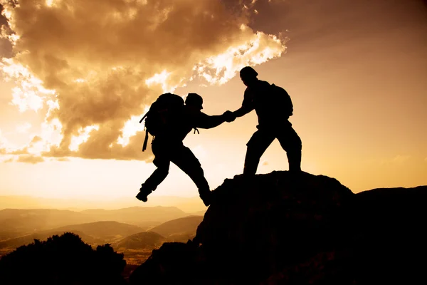 Mountaineering aid ;Climbing activities and successful climb.The importance of cooperation and solidarity .To overcome the challenges of mountain life . — Stock Photo, Image