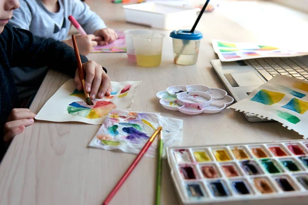 子供たちはアートレッスン中に水彩絵具で絵を描く。人形はブラシで描くことに集中しています。水彩ホイールとパレット。色論初心者趣味レッスン — ストック写真