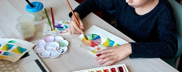 美術の授業中に水彩絵具で少年絵を描く。筆で絵を描く。水彩ホイールとパレット。色論初心者趣味レッスン — ストック写真