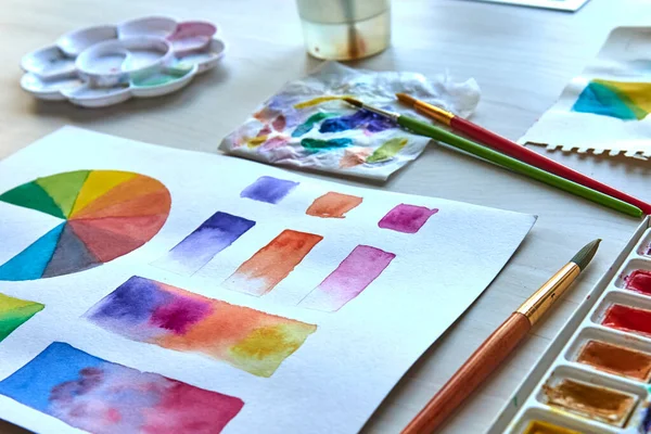 Artist\'s workplace. Art supplies brushes, paints, watercolors. Art studio. Drawing lessons. Creative workshop. Design place. Watercolor color wheel and palette. Color theory beginner hobby lessons.