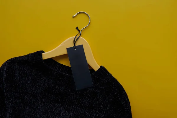 Percha Madera Con Suéter Negro Acogedor Etiqueta Papel Aislado Sobre — Foto de Stock