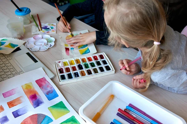 子供たちはアートレッスン中に水彩絵具で絵を描く 人形はブラシで描くことに集中しています 水彩ホイールとパレット 色論初心者趣味レッスン — ストック写真