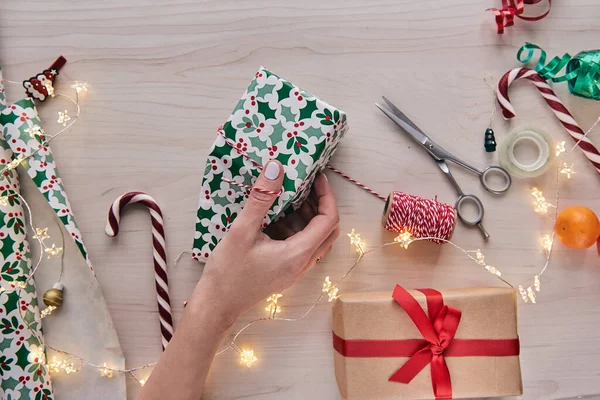 Christmas composition. Giftboxes, presents wrapping with paper and ribbon, lights, candy canes on wooden background. Holdiay DIY handmade home decoration. Winter, new year Flat lay, top view — Stock Photo, Image