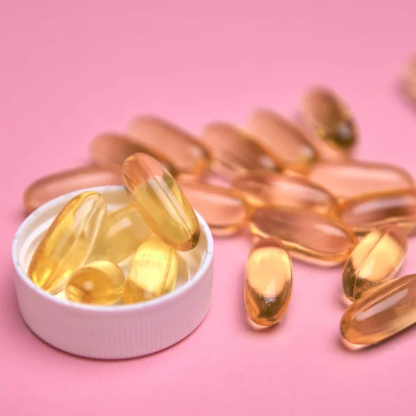 Muitas pílulas transparentes Omega 3 ou óleo de peixe em um fundo colorido. Suplementos de saúde e medicamentos — Fotografia de Stock